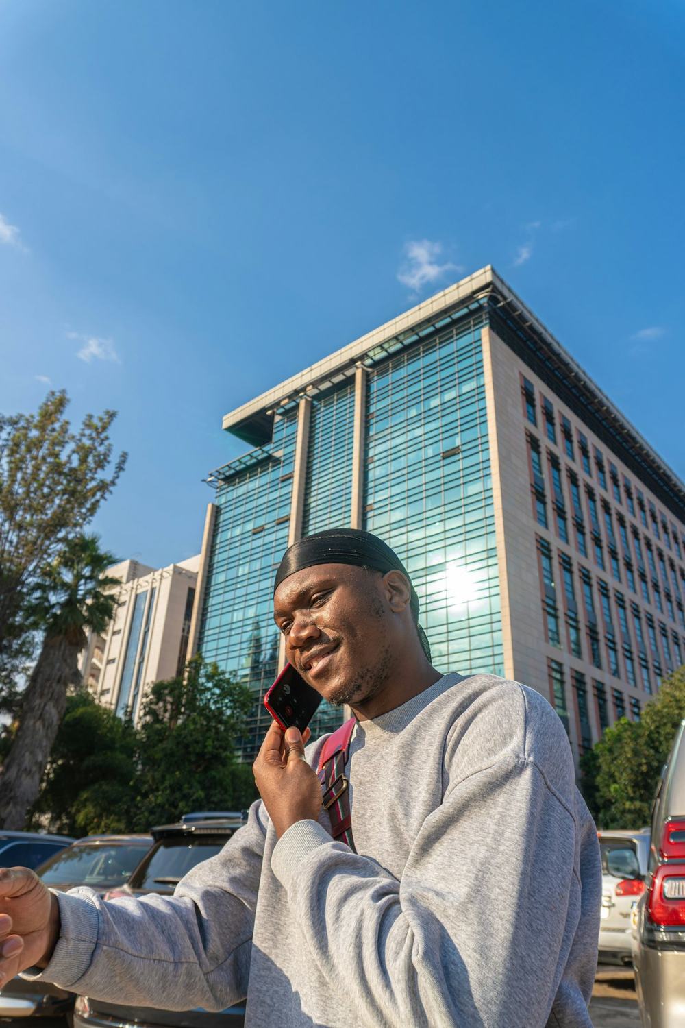 Businessman on a phone call outside a modern office tower in Kigali